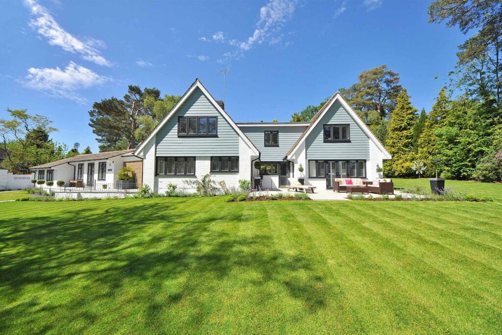 Blue and white house sits on manicured lawn