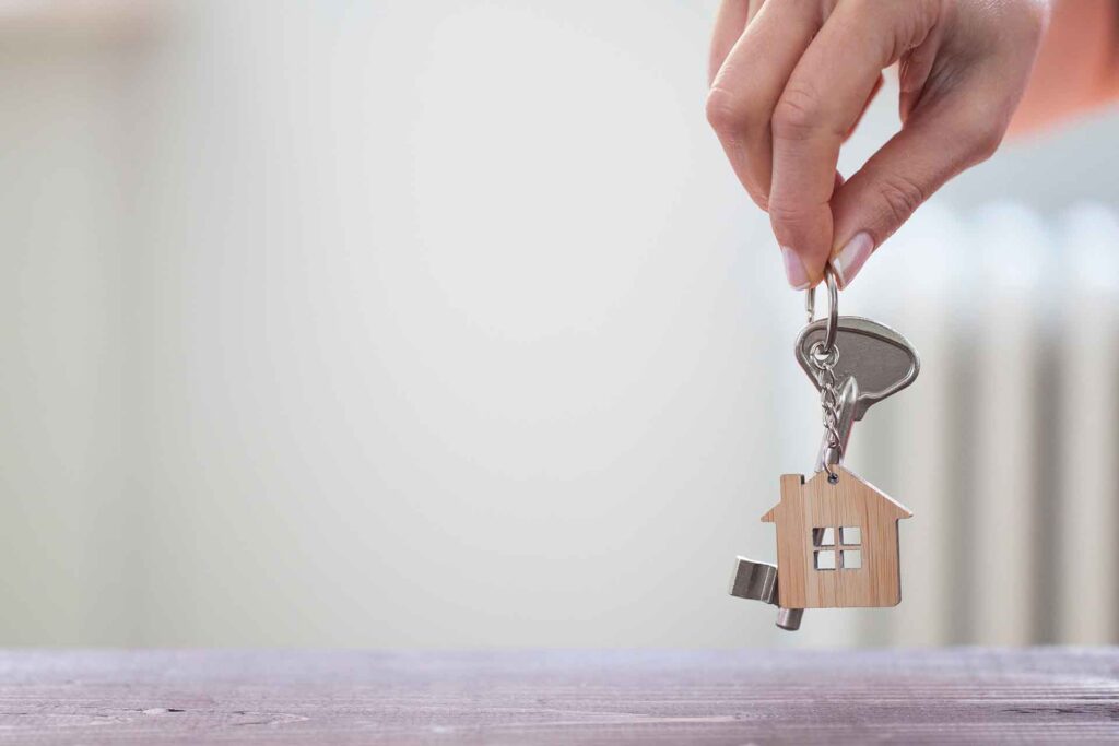 A key ring with a wooden keychain shaped like a house.