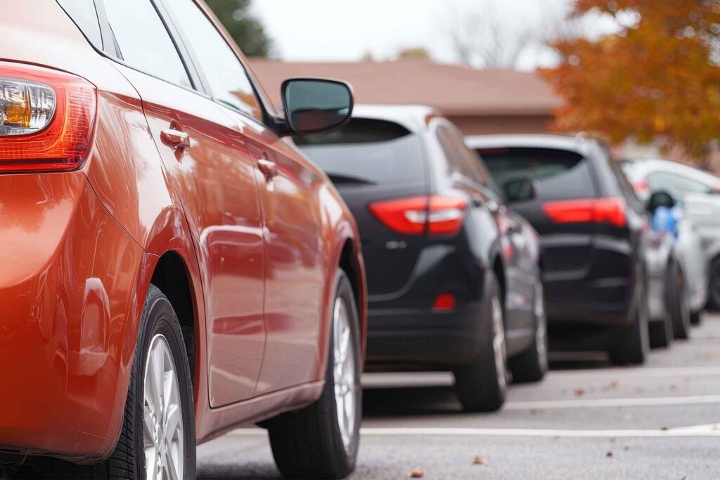 A line of cars sit in a parking lot