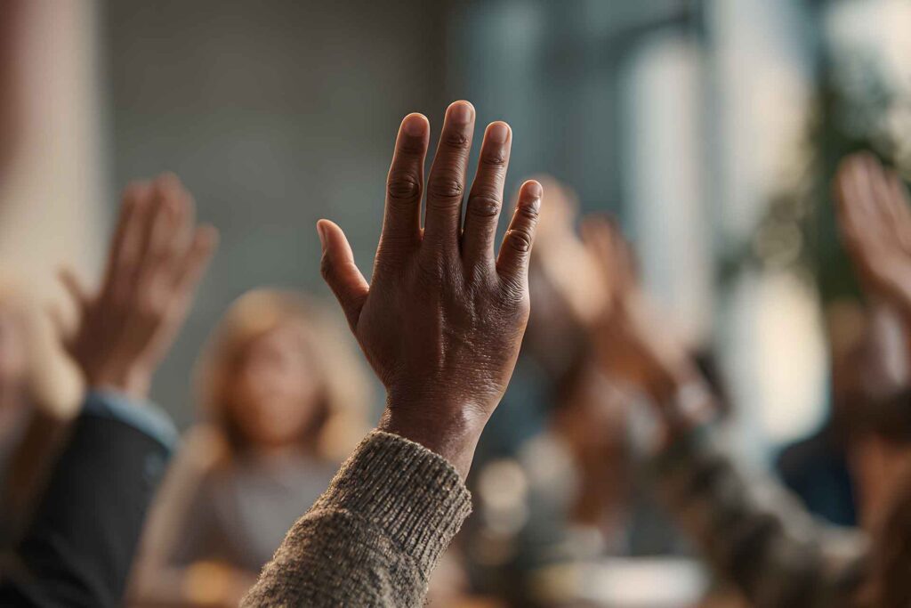 Person raises hand to vote in HOA meeting